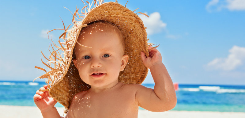 Bébé sur la plage avec un chapeau